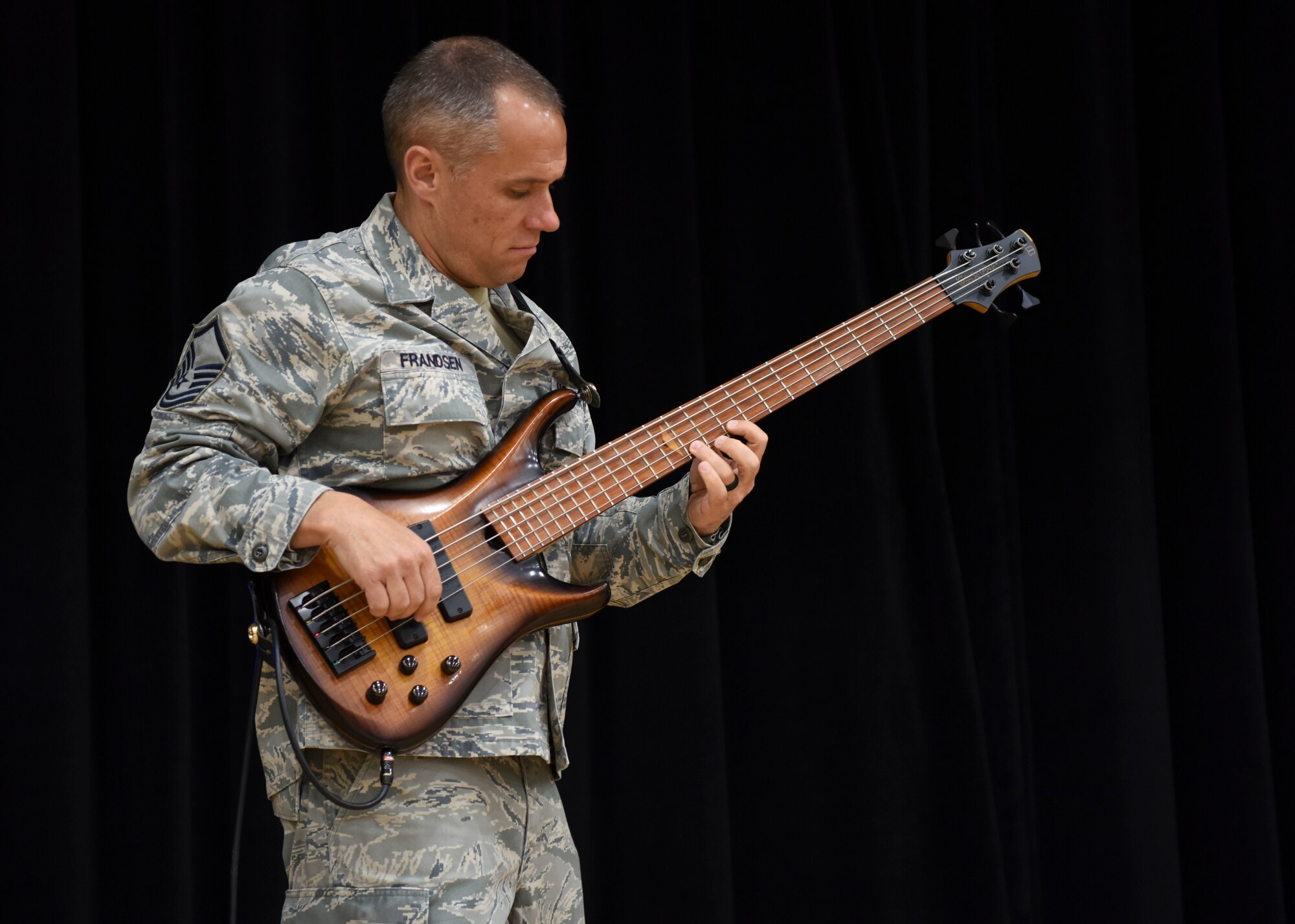 U.S Air Force Master Sgt. Mark Frandsen, U.S. Air Force Band of the Pacific Trends bass player, warms up before the band’s performance at Osan Middle High School, Osan Air Base, Republic of Korea, May 7, 2018. The concert’s set included American songs from today’s pop culture and classic rock from the 1980s, with solos from the various band members. (U.S. Air Force photo by Airman 1st Class Ilyana A. Escalona)