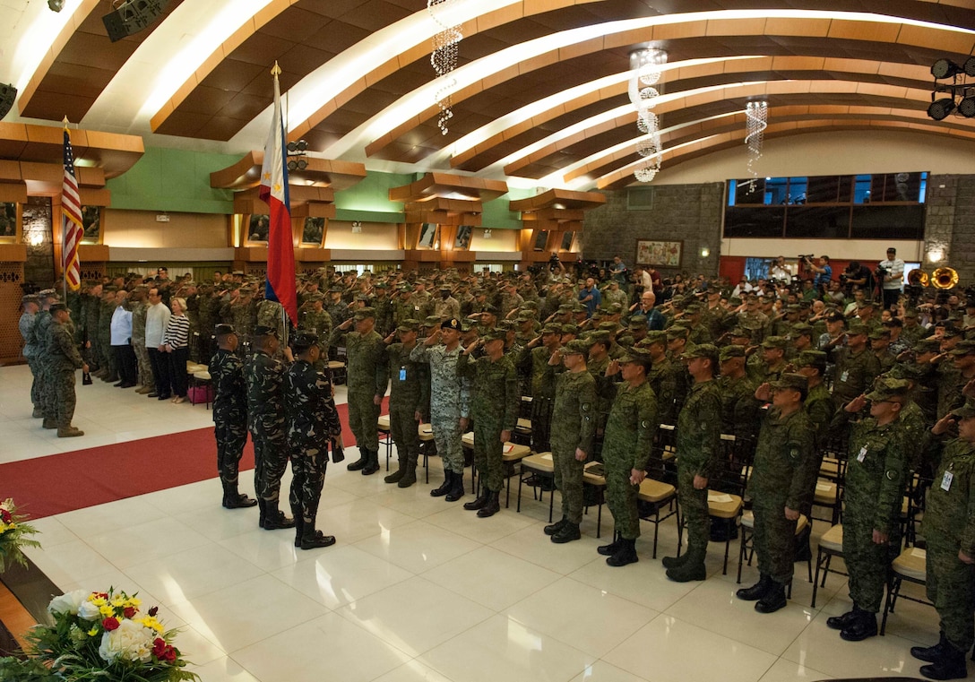 Philippine, U.S., Japanese, and Australian service members render honors during the presentation of colors at the Exercise Balikatan opening ceremony held at Tejeros Hall, Camp General Emilio Aguinaldo, Quezon City, Manila, Philippines, May 7, 2018. The ceremony represented the official commencement of Exercise Balikatan and the continued partnership between the United States and the Republic of the Philippines. Exercise Balikatan, in its 34th iteration, is an annual U.S.-Philippine military training focused on a variety of missions, including humanitarian assistance and disaster relief, counterterrorism, and other combined military operations held from May 7 to May 18. (U.S. Navy photo by Mass Communication Specialist 2nd Class Markus Castaneda)