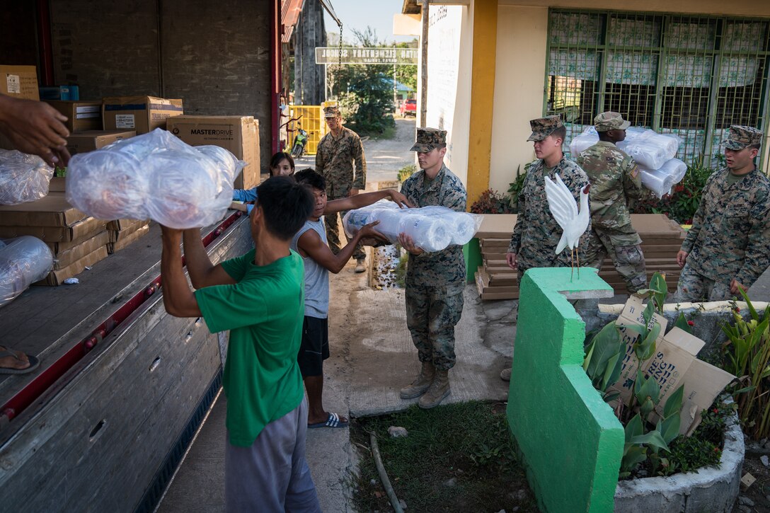 U.S. service members help offload a truck full of supplies in support of Exercise Balikatan at Calangitan Elementary School in Capas, Tarlac, Philippines, April 19, 2018. Balikatan 34-2018, in its 34th iteration, is an annual U.S.-Philippine military training exercise focused on a variety of missions, including humanitarian assistance and disaster relief, counterterrorism and other combined military operations held from May 7 to 18. (U.S. Marine Corps photo by Sgt. Matthew J. Bragg)