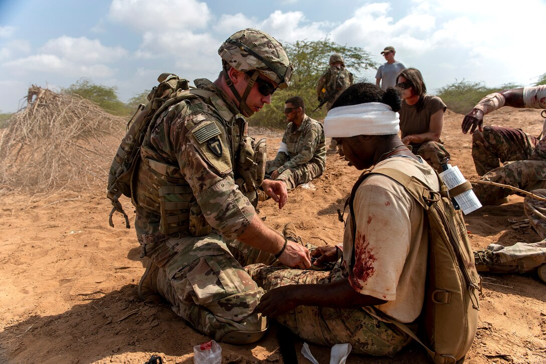 A soldier provides medical aid to a role-playing casualty.