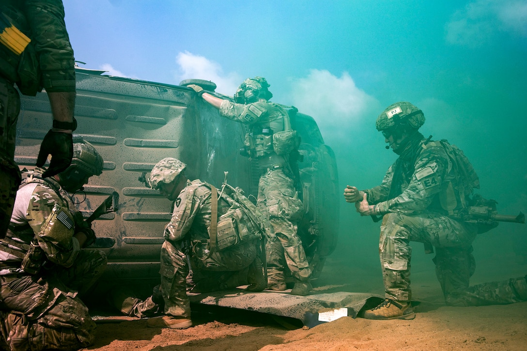 Airmen and soldiers work to rescue a simulated casualty.