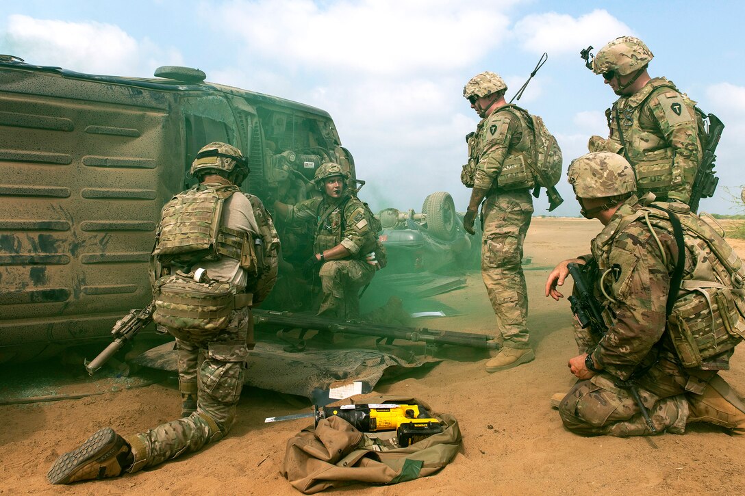 Airmen and soldiers work to rescue a role-playing casualty.