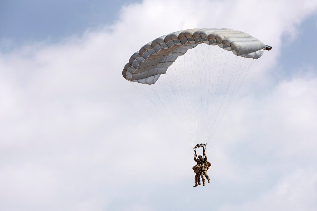 A pararescueman and a doctor conduct a tandem high altitude, low-opening jump.