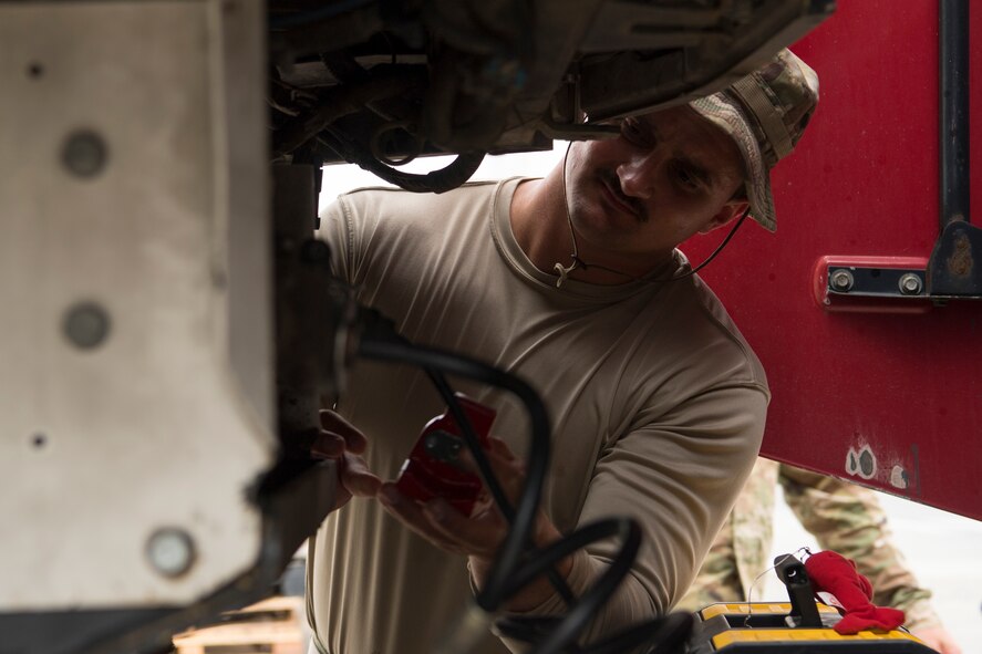 Staff Sgt. Colin Poss, 386th Expeditionary Force Support Squadron warehouse specialist from Sioux City, Iowa, inserts a Glad Hand Lock on the air brakes of a semi-truck at an undisclosed location in Southwest Asia, May 2, 2018. Poss, an Air National Guard member from Sioux City, Iowa, brought this tool with him from his civilian job as a warehouse manager. (U.S. Air Force photo by Staff Sgt. Joshua King)