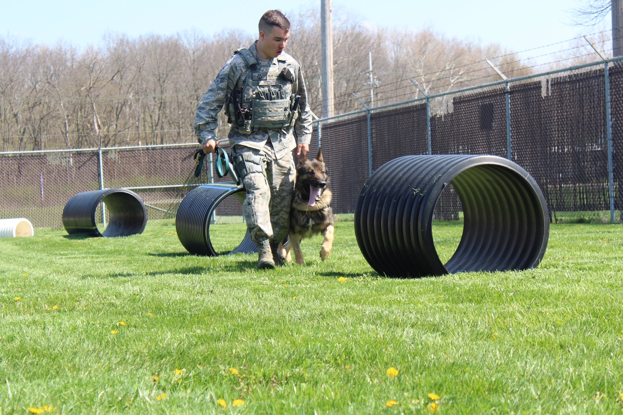 Military working dogs at the 88th Security Forces Squadron are either out on patrol or stay at the kennel to train. Senior Airman Marshall Freeman, 88th Security Forces military working dog handler takes his partner through the obstacle course located at the MWD kennel. (U.S. Air Force photo/Stacey Geiger)