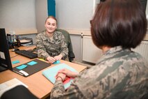 U.S Air Force Airman 1st Class Samantha Roppo, 100th Force Support Squadron force management journeyman, assists a customer with questions, at RAF Mildenhall, England, April 17, 2018. Force management handles any updates to records, such as promotions, demotions or any change in duty status. (U.S. Air Force photo by Senior Airman Christine Groening)