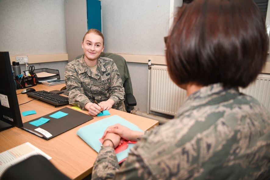 U.S Air Force Airman 1st Class Samantha Roppo, 100th Force Support Squadron force management journeyman, assists a customer with questions, at RAF Mildenhall, England, April 17, 2018. Force management handles any updates to records, such as promotions, demotions or any change in duty status. (U.S. Air Force photo by Senior Airman Christine Groening)