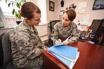 U.S. Air Force Senior Master Sgt. Nicole Hicks, 100th Force Support Squadron Military Personnel Flight superintendent, mentors U.S. Air Force Airman 1st Class Jasmine Zent, 100th Force Support Squadron Force Management apprentice, at RAF Mildenhall, England, April 17, 2018. When Airmen or civilians have a change in life circumstances, such as getting married, divorced or having a baby, the MPF staff are on hand to make critical updates that can affect pay. (U.S. Air Force photo by Senior Airman Christine Groening)
