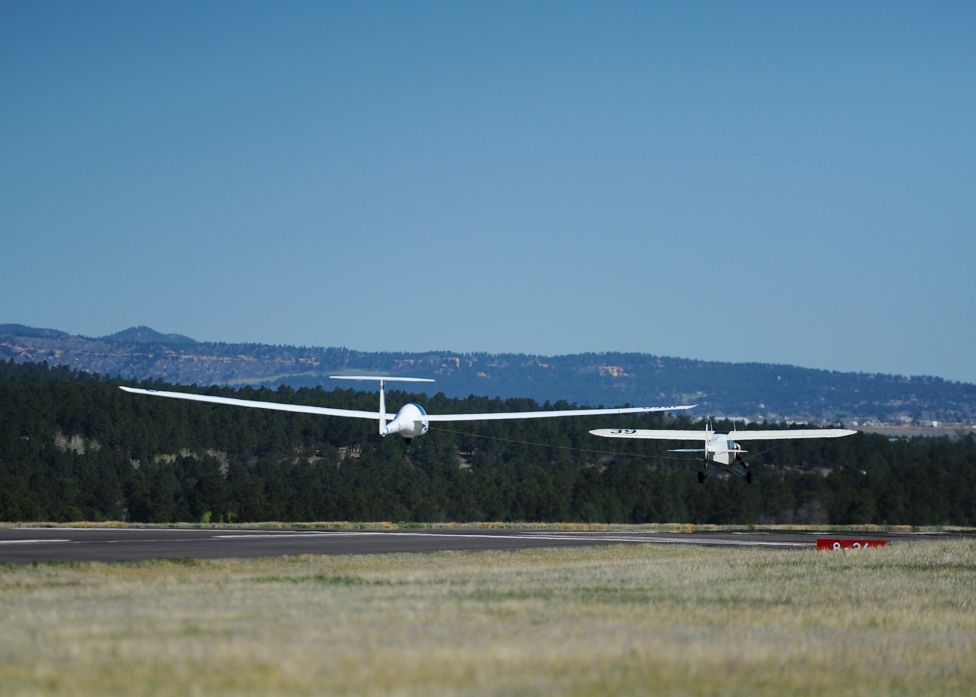 An aircraft tows a glider during an orientation flight for the wounded warriors May 8, 2018, at the Air Force Academy, Colo. Eight veterans received an opportunity to ride on a glider and soar over the Front Range. (U.S. Air Force photo/Master Sgt. Julius Delos Reyes)
