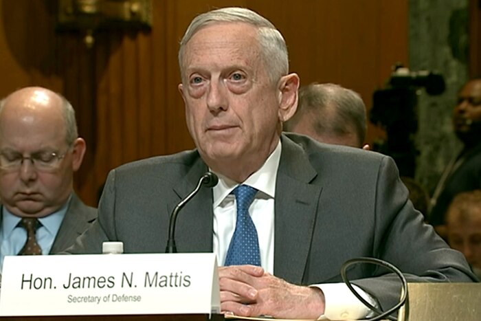 Defense Secretary James N. Mattis sits behind a desk.