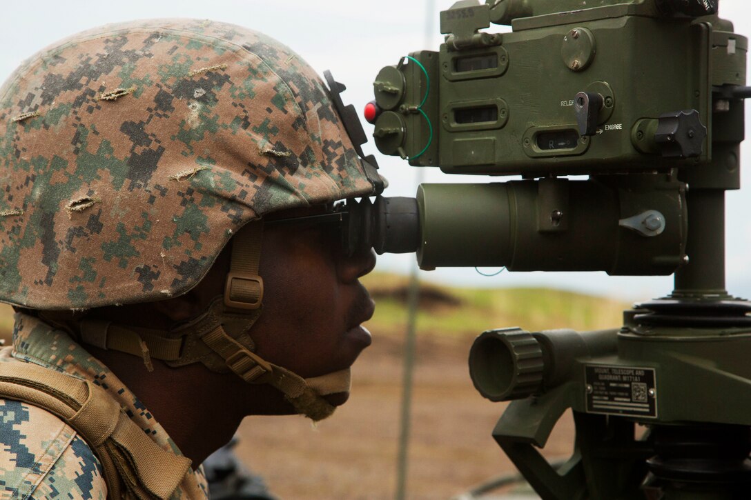 A Marine checks the target grid coordinates on a howitzer.