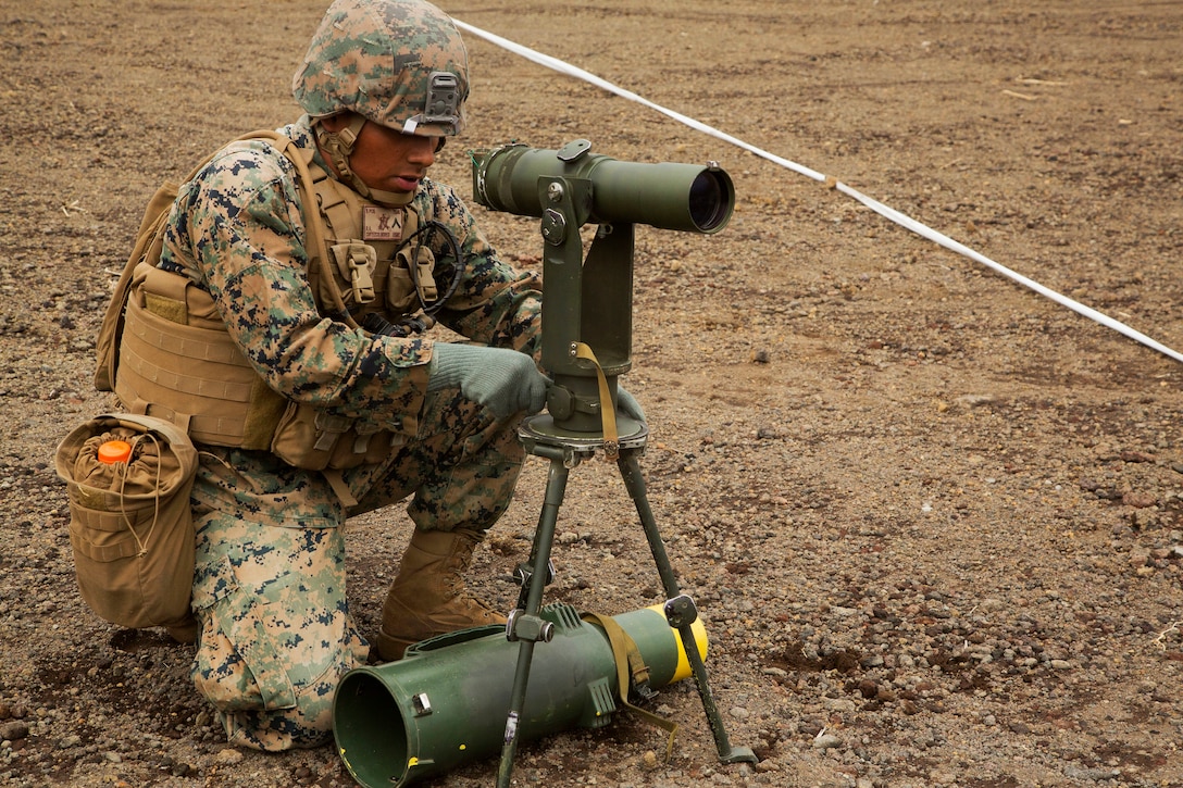 A Marine sets up a targeting optic during live-fire training.