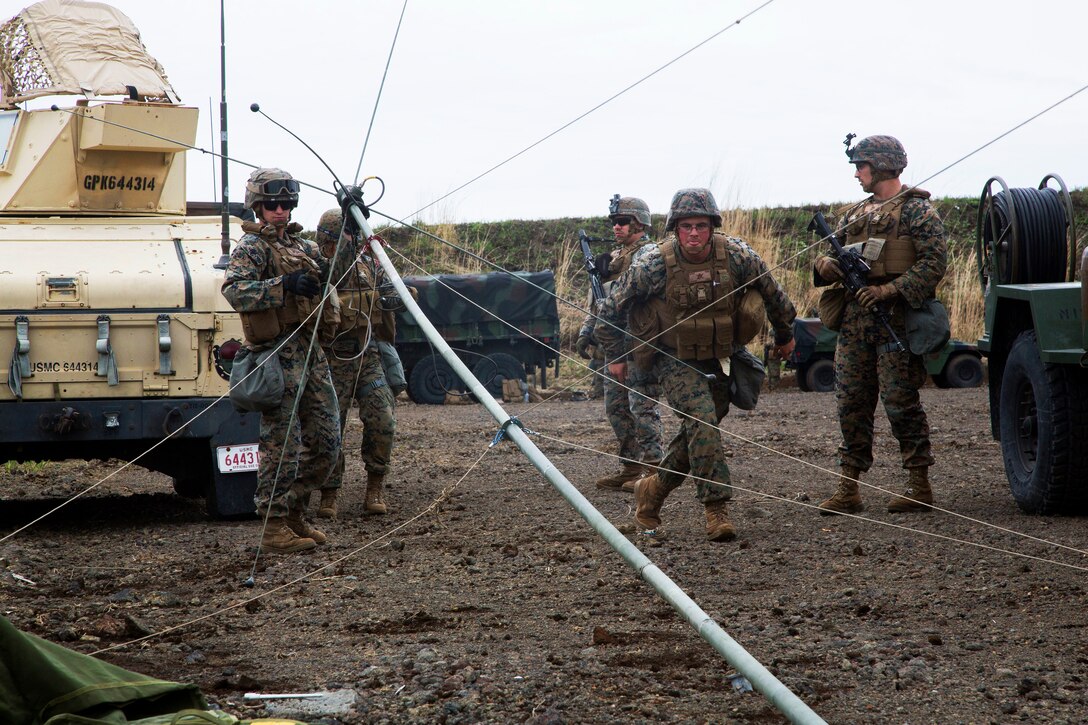 Marines set up an antenna during an artillery live-fire exercise.