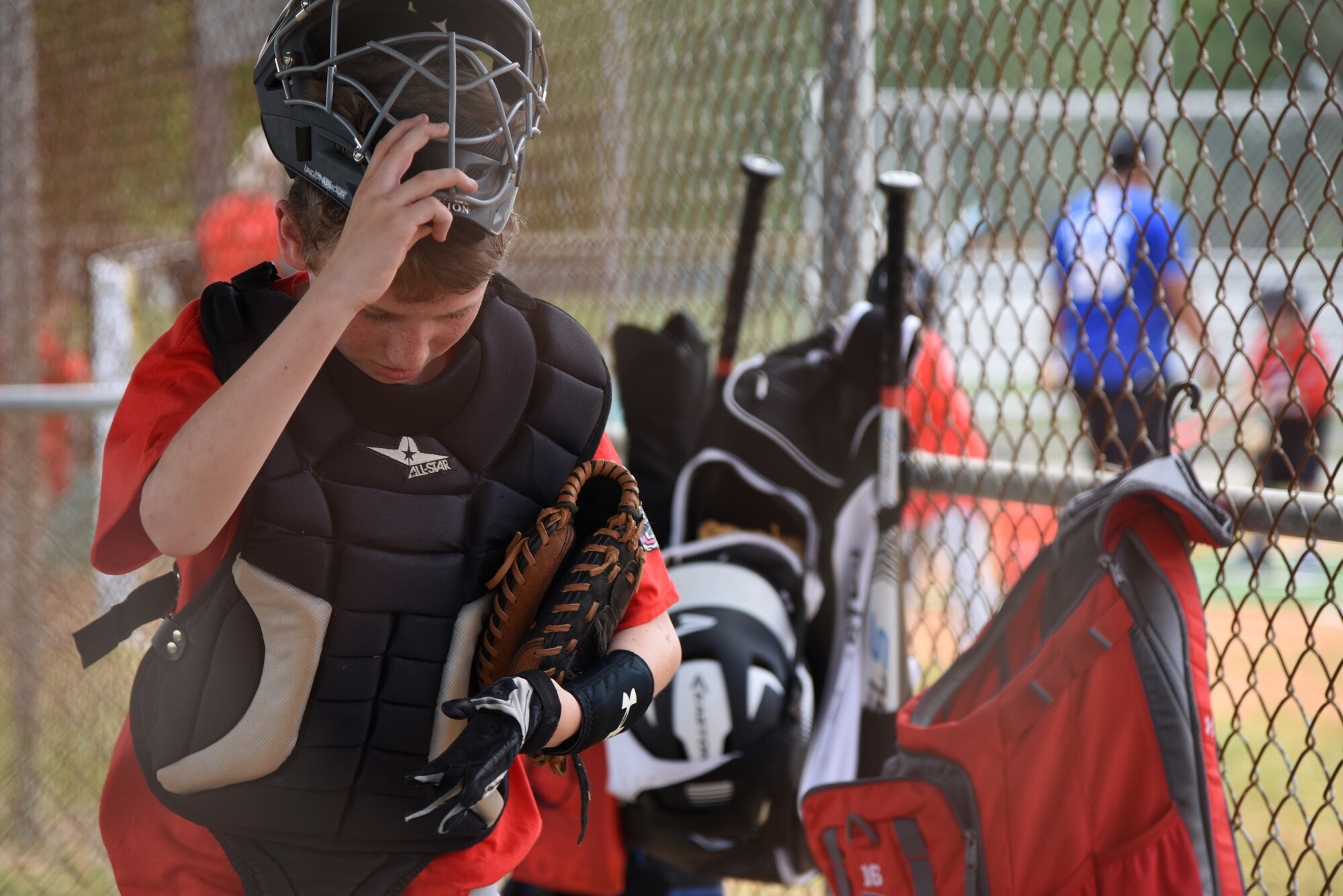 Tristan Fisher, son of U.S. Air Force Chief Master Sgt. Anthony Fisher, 81st Training Group superintendent, puts on his catcher’s gear during the Biloxi Shuckers Youth Baseball Clinic on the youth center baseball field at Keesler Air Force Base, Mississippi, May 5, 2018. The clinic provided hitting, pitching, base running and fielding instruction from members of the Biloxi Shuckers minor league baseball team. (U.S. Air Force photo by Kemberly Groue)