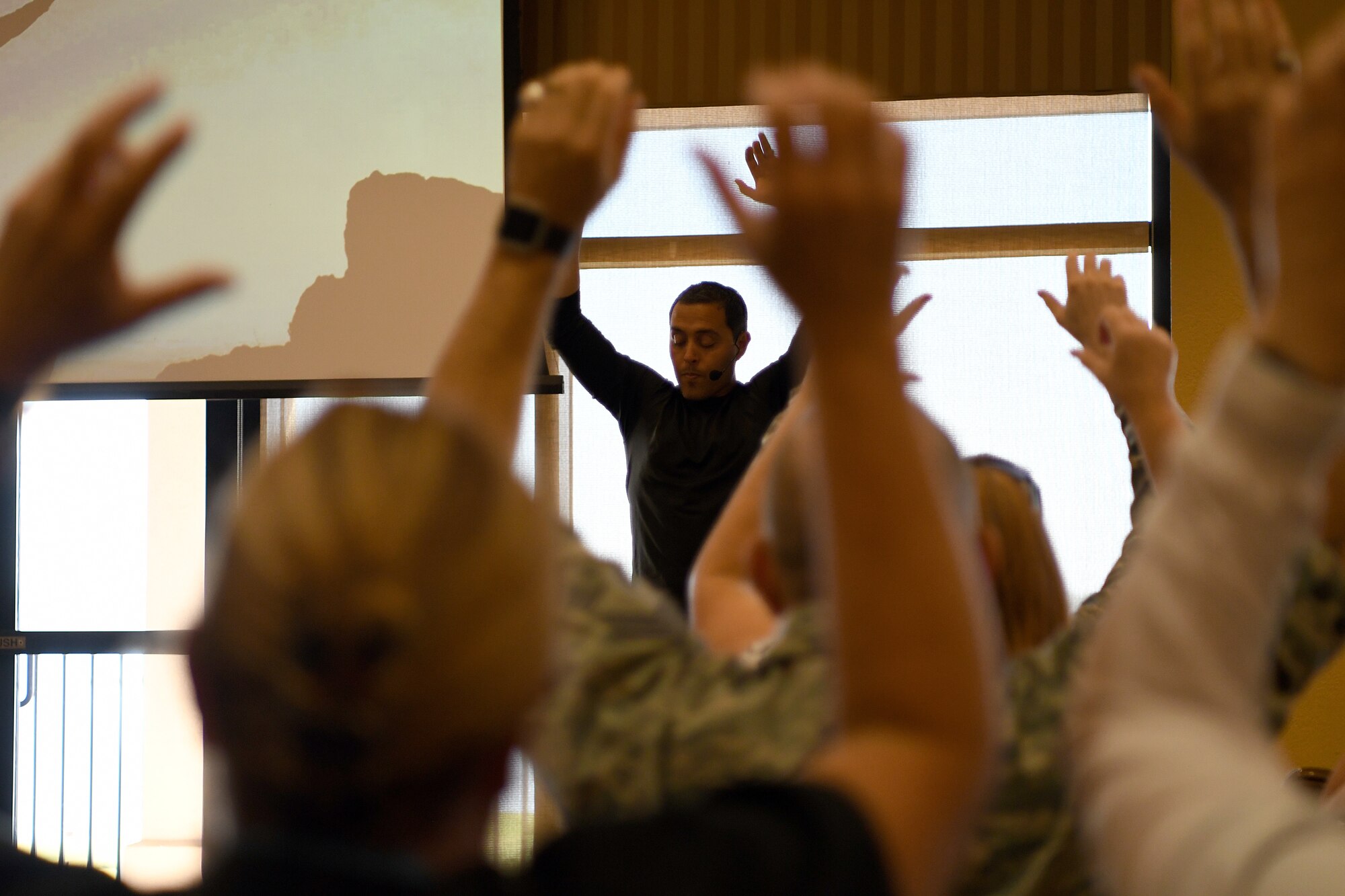 Jairek Robbins, performance coach, and Keesler personnel  participate in a breathing exercise during a private mentoring session in the Bay Breeze Event Center at Keesler Air Force Base, Mississippi, May 7, 2018. Approximately 100 Keesler members signed up for “The Complete Guide to Activating High Performance” course, a 4-week online training course with weekly guided face-to-face discussions as well as a private mentoring session with Robbins. (U.S. Air Force photo by Airman 1st Class Suzie Plotnikov)