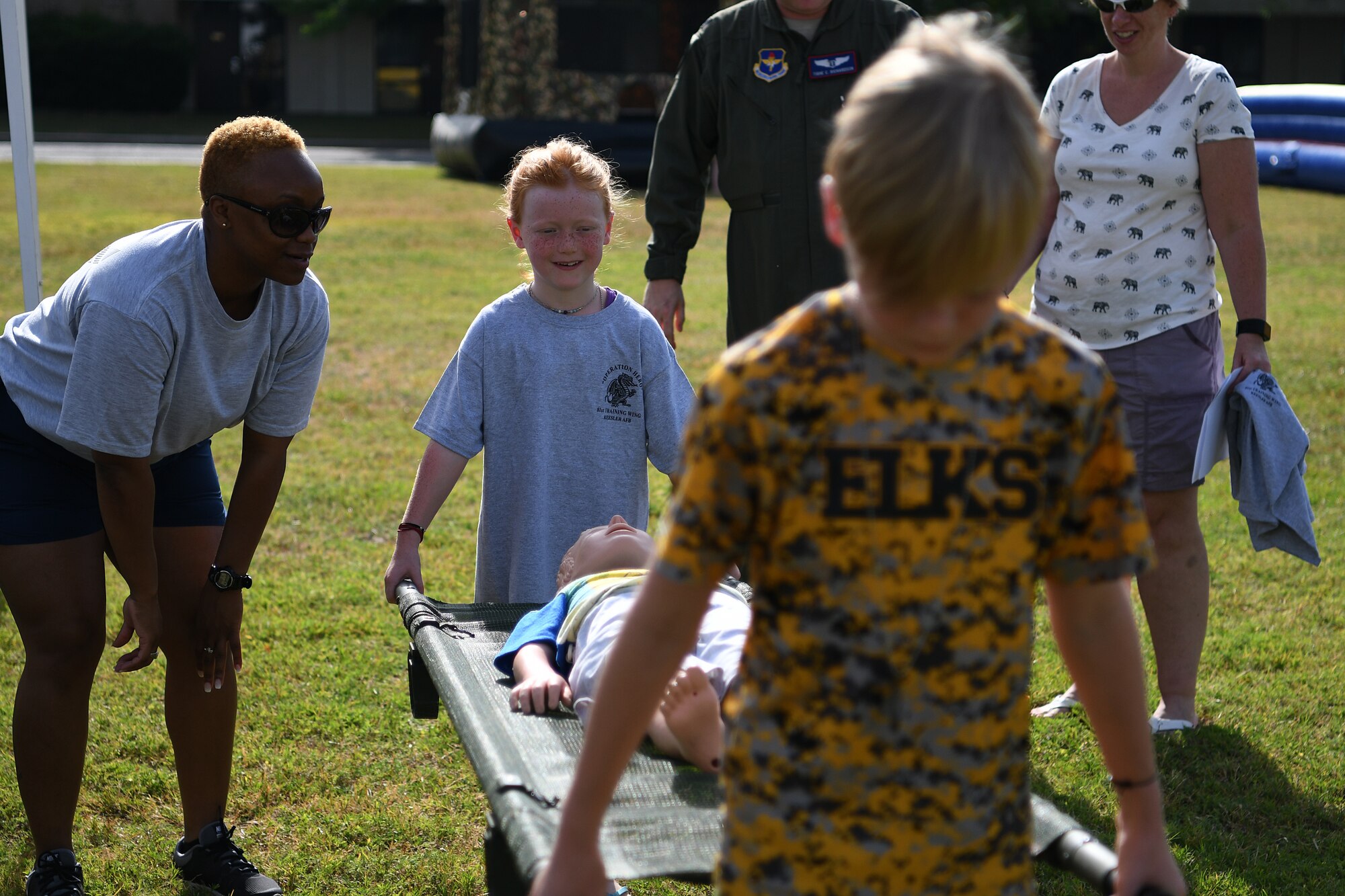 Mackenna and Maxon Richardson, children of U.S. Air Force Lt. Col. Tighe Richardson, 81st Medical Group ophthalmology and refractive surgery chief, perform a litter carry during Operation Hero at Keesler Air Force Base, Mississippi, May 5, 2018. During the event, children had different tasks to complete before getting a tour of a C-130J Hercules . (U.S. Air Force photo by Airman 1st Class Suzie Plotnikov)