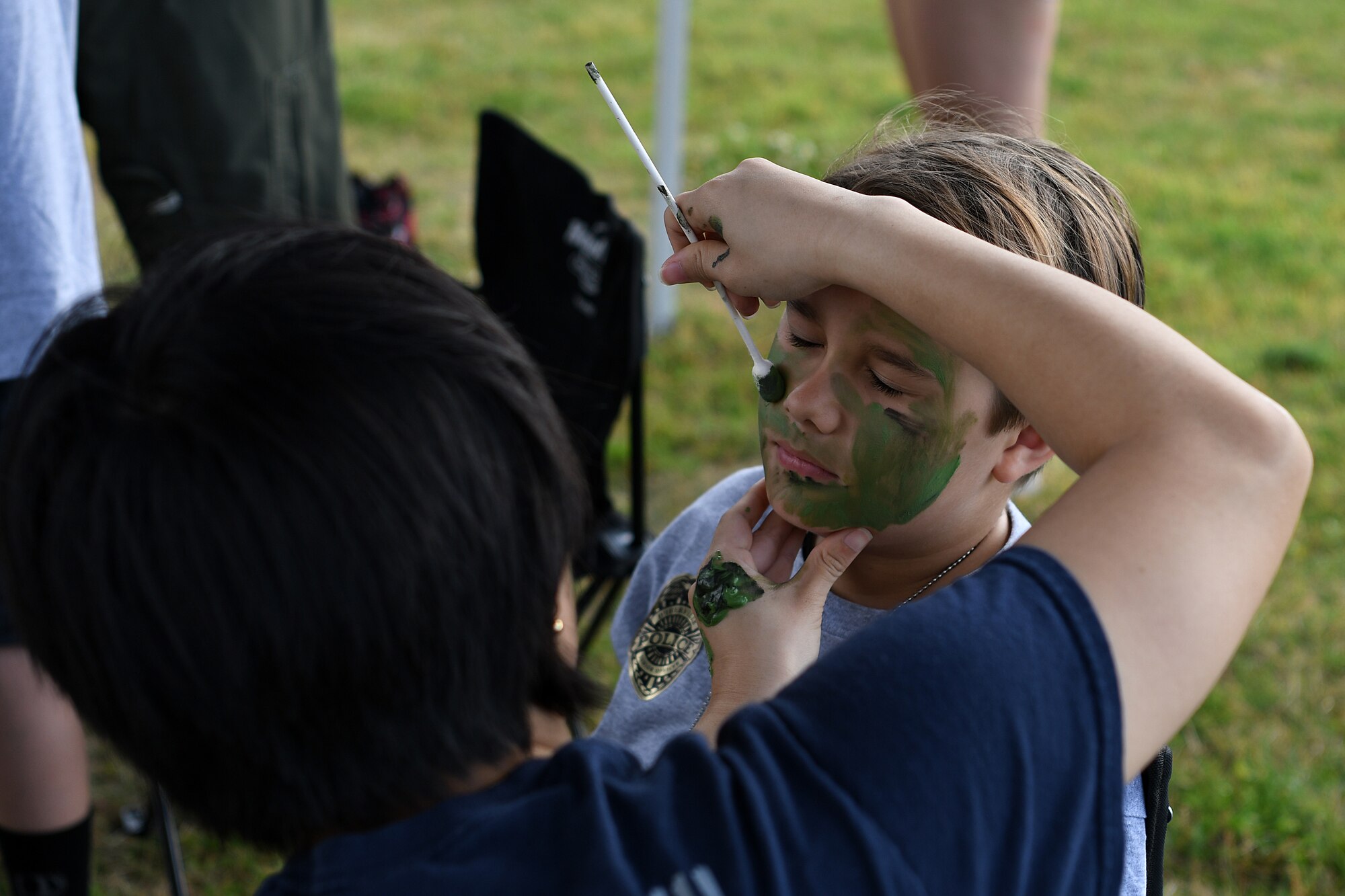 U.S. Air Force Senior Airman Thanh Le, 81st Force Support Squadron installation personnel readiness specialist, applies face paint to Christian Canessa, family member of Senior Airman Nicole Rivera, 81st Medical Group biomedical equipment technician, at Keesler Air Force Base, Mississippi, May 5, 2018. The event gave military children a glimpse into the lives of deployed military members. (U.S. Air Force photo by Airman 1st Class Suzie Plotnikov)
