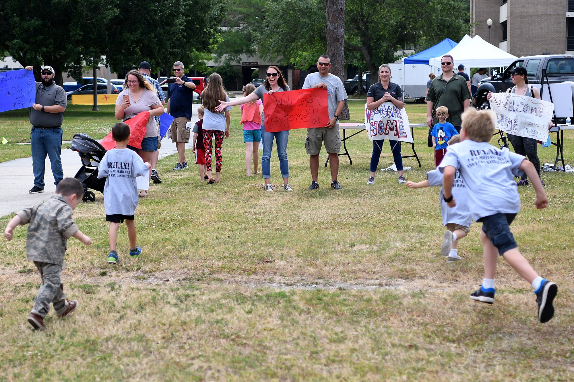 Keesler children run to their parents during Operation Hero at Keesler Air Force Base, Mississippi, May 5, 2018. The children were welcomed by their parents as they came “home” from a simulated deployment after receiving a tour of a C-130J Hercules. (U.S. Air Force photo by Airman 1st Class Suzie Plotnikov)