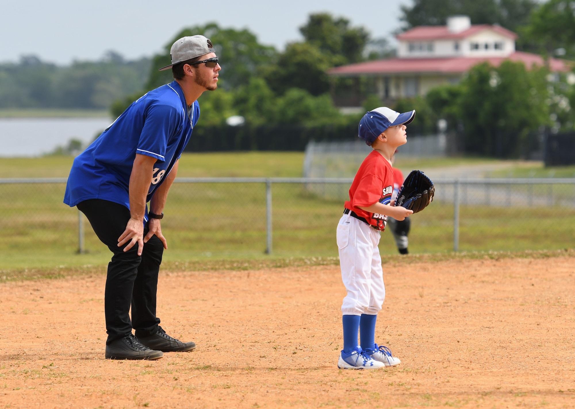 Dylan Moore, Biloxi Shuckers shortstop, assists Bradley Gaines, son of U.S. Air Force Capt. Sheila Gaines, 81st Medical Operations Squadron nurse, with fielding techniques during the Biloxi Shuckers Youth Baseball Clinic on the youth center baseball field at Keesler Air Force Base, Mississippi, May 5, 2018. The clinic provided hitting, pitching, base running and fielding instruction from members of the Biloxi Shuckers minor league baseball team. (U.S. Air Force photo by Kemberly Groue)