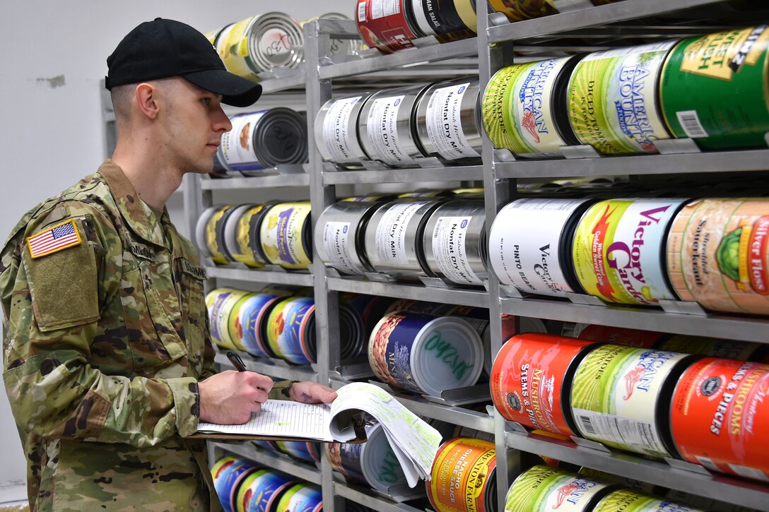 A soldier conducts a food supply inventory.
