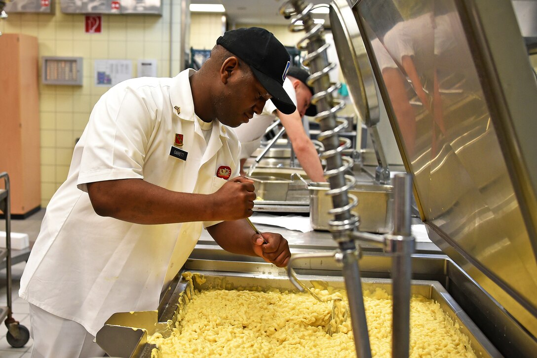 A culinary specialist cooks macaroni and cheese.