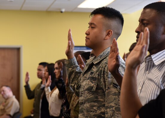 Service members in a court room wait for naturalization.