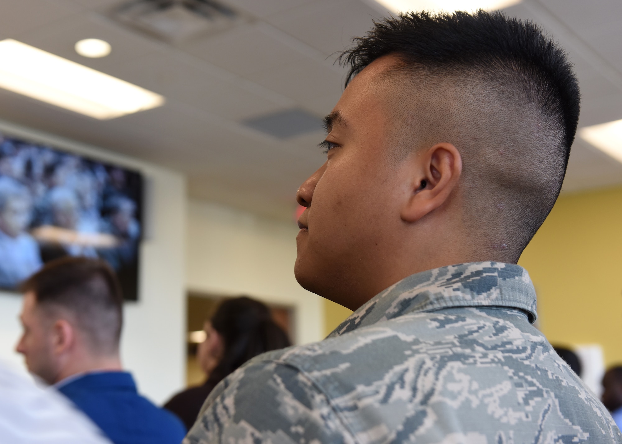 Service members in a court room wait for naturalization.