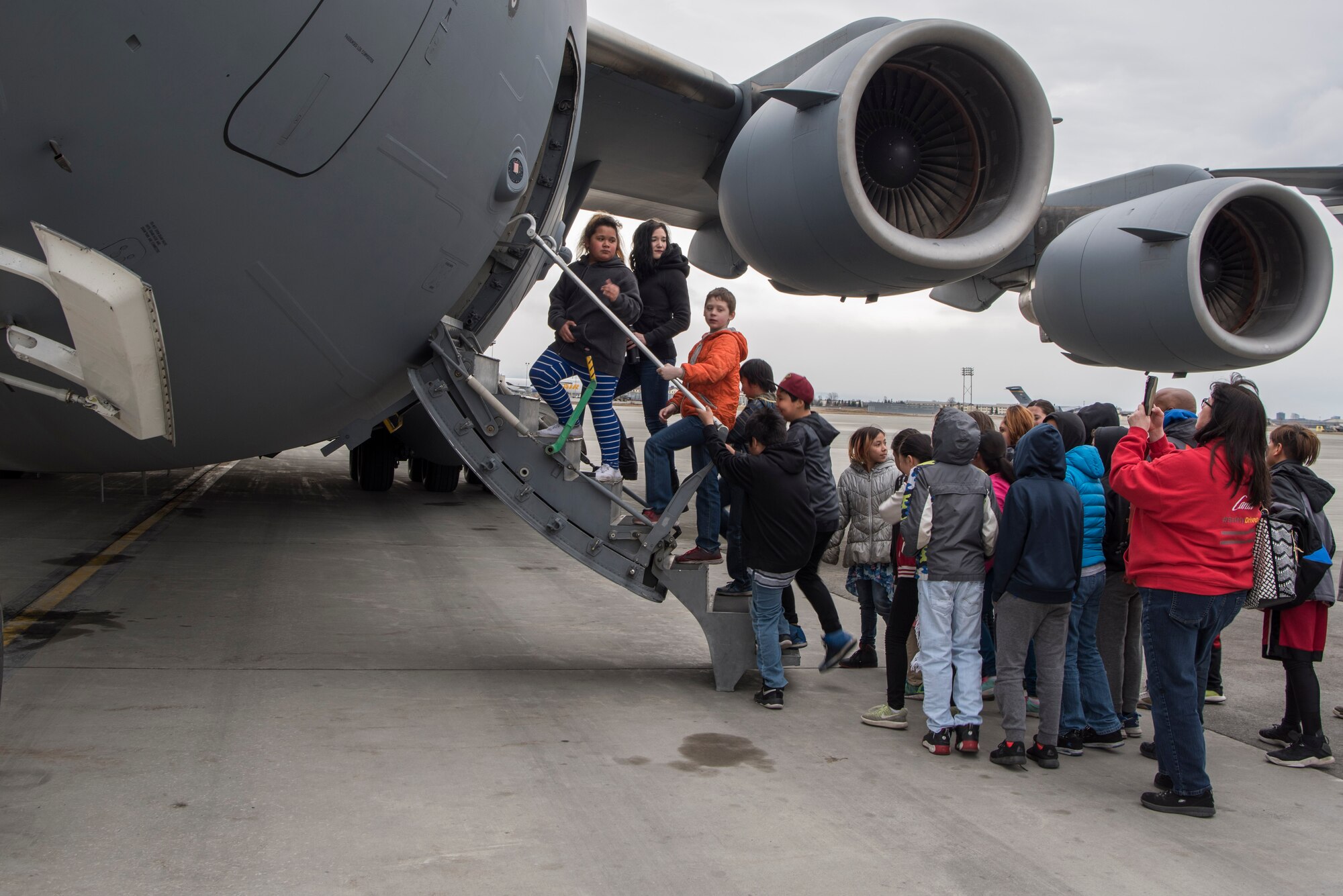 Students in 5th-grade from Wonder Park and Mountain View elementary schools and chaperones enter a C-17 Globemaster III static display at the “Day in the Life of Airmen” tour on Joint Base Elmendorf-Richardson, Alaska, May 4, 2018. Subject-matter experts led the students through displays of a C-17, F-22 Raptor, Aerospace Ground Equipment, and more. The tour included a pilot, loadmaster, crew chief and several other SMEs to speak about the displays.