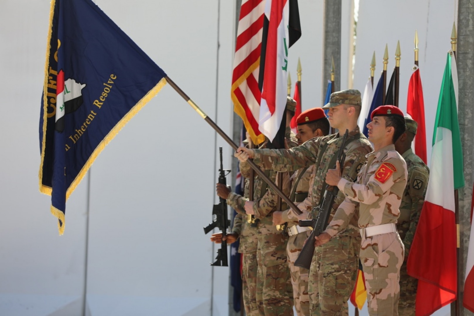 Coalition members with the Combined Joint Forces Land Component Command color guard render a salute during the command’s deactivation ceremony at Baghdad, Iraq.