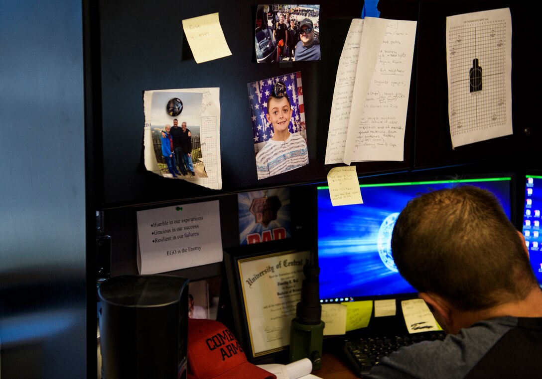 Officer Tim Bull, a Combat Arms Training and Maintenance instructor, does paperwork at his desk, April 26, 2018, at the CATM building on Patrick Air Force Base. Bull has a son, Gage, who is in the 5th grade. Bull did not overcome addiction on the first try, it took him four times to quit, each time bouncing back better and better in the process. Bull demonstrates perseverance, hard work, and becoming a role model not only to his son, but others as well. (U.S. Air Force photo by Airman 1st Class Dalton Williams)