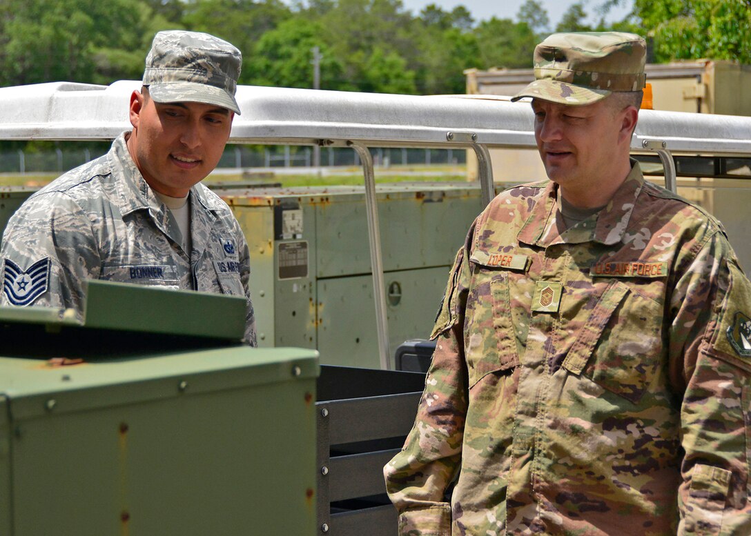 Chief Master Sgt. James Loper, 10th Air Force Command Chief, listens as Tech. Sgt. William Bonner, 919th Special Operations Communications Squadron, gives him an overview