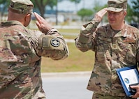 Chief Master Sgt. James Loper, 10th Air Force Command Chief, salutes Lt. Col. Christopher Johnson, 919th Special Operations Communications Squadron commander