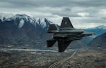 F-35A Aircraft banks in front of mountain background