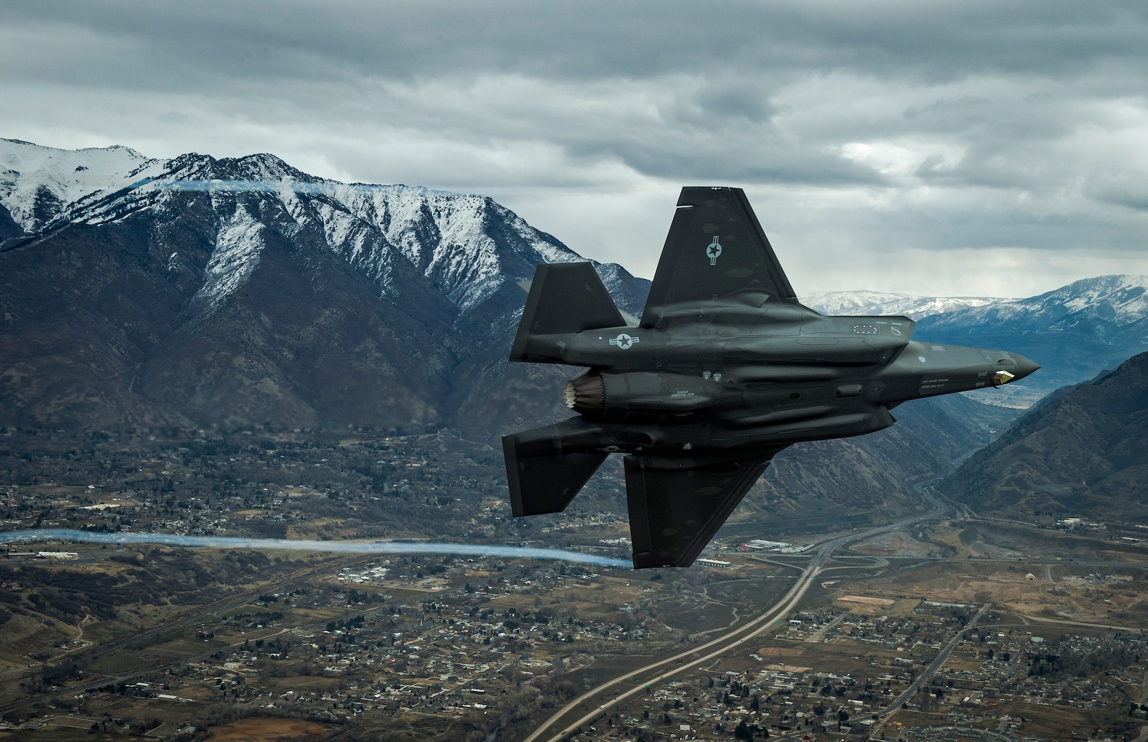 F-35A Aircraft banks in front of mountain background