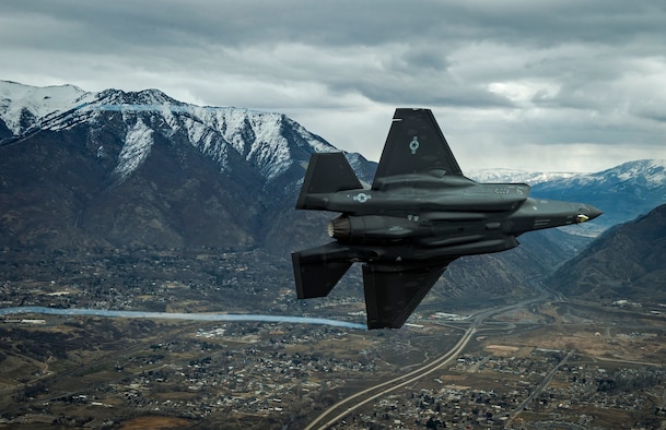 F-35A Aircraft banks in front of mountain background
