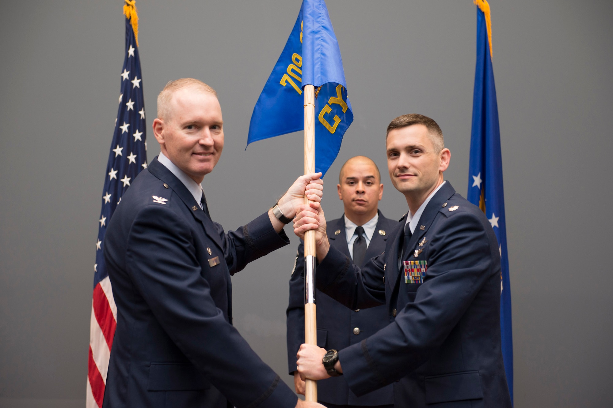 Lt. Col. Nathan Loyd (right), 709th Cyberspace Squadron commander, accepts his squadron’s guidon from Col. Richard Mendez, 709th Support Group commander, during a ceremony at the Air Force Technical Applications Center, Patrick AFB, Fla., April 11, 2018.  Loyd assumed command of the newly-formed squadron after the nuclear treaty monitoring center reorganized to improved mission effectiveness.  Pictured in background is Master Sgt. Brian Bowles, ceremonial guidon bearer.  (U.S. Air Force photo by Matthew S. Jurgens)
