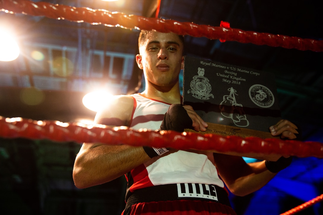 U.S. Marine Corps Cpl. Joshua Vera, right, a water support technician with 7th Engineer Support, 1st Marine Logistics Group, and boxer with the 1st Marine Division (MARDIV) boxing team, is declared the winner of the second bout against British Royal Marine (RM) Sgt. Daniel Brinks, in a boxing competition at Commando Training Centre for the Royal Marines Lympstone, England, May 3, 2018