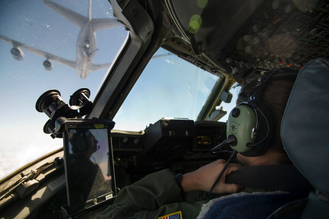 Capt. Cari Piha, and Maj. Toni Merhar, 535th Airlift Squadron C-17 Globemaster III pilots, watch a KC-135 Stratotanker during an in-flight refueling mission, Joint Base Pearl Harbor-Hickam, Hawaii, April 25, 2018. The aircrew featured mothers to celebrate mothers who serve in the military and to highlight challenges Airmen face when balancing families and career. (U.S. Air Force photo by Tech. Sgt. Heather Redman)