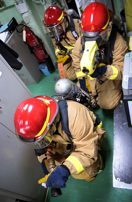 Sailors combat a simulated Class A fire during a damage control drill.