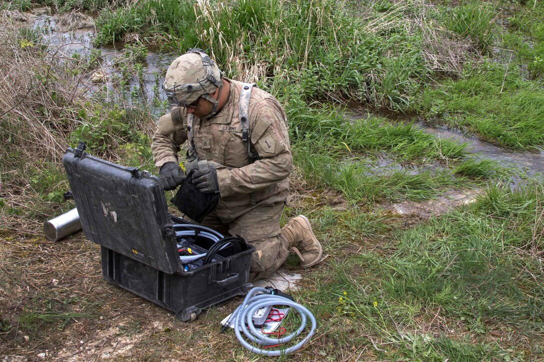 A soldier sets up a Versa Pak water purification system.