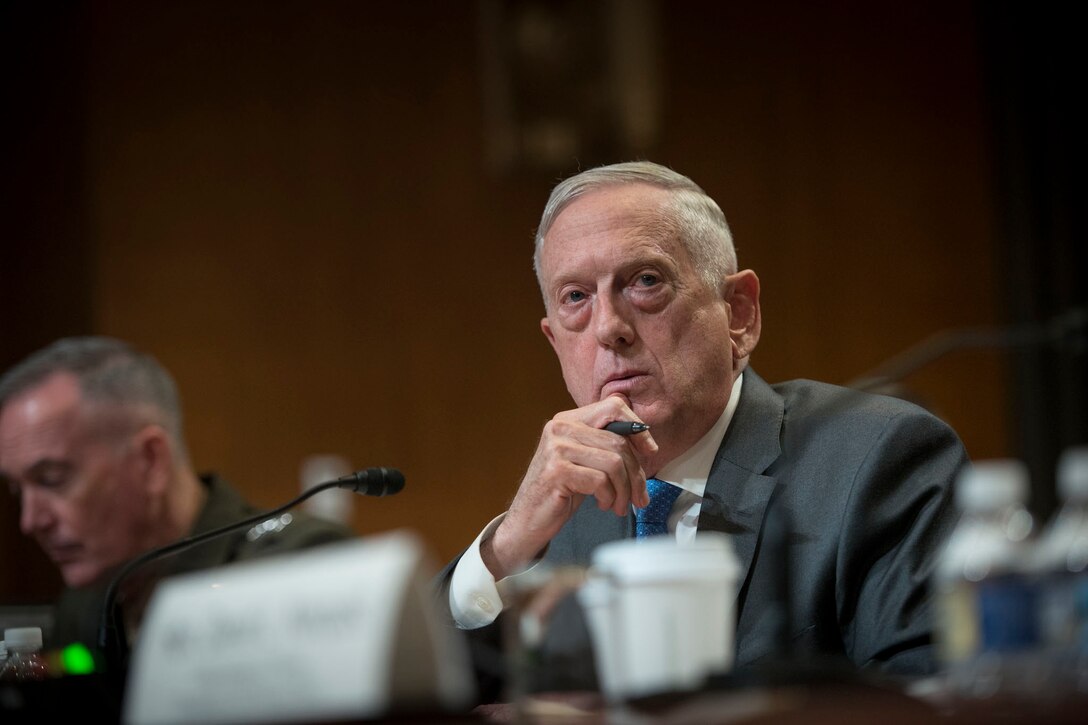 Defense Secretary James N. Mattis sits behind the desk.