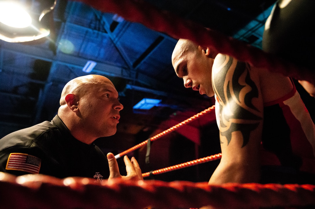 U.S. Marine Corps Sgt. Kemuel Sanchez, a motor vehicle operator with 1st Marine Raider Battalion, Marine Corps Forces Special Operations Command, and boxer with the 1st Marine Division (MARDIV), receives coaching advice from his coach Kevin Kylis, during a one-minute break between rounds in a boxing competition at Commando Training Centre for the Royal Marines Lympstone, England, May 3, 2018.