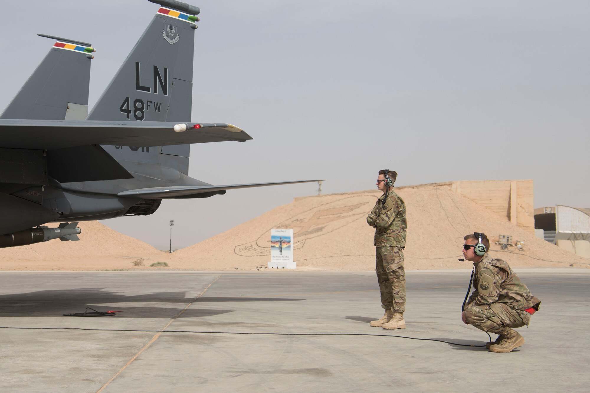 Two Airmen with the 332nd Expeditionary Maintenance Squadron observes the engine of an F-15E Strike Eagle as they perform pre-flight checks May 7, 2018, at an undisclosed location in Southwest Asia.