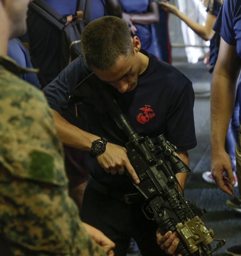 A poolee with Marine Recruiting Station Fort Lauderdale holds an M4A1 Carbine during ship tours aboard the USS Kearsarge as part of Fleet Week Port Everglades, Fort Lauderdale, Florida, May 5, 2018. Fleet Week showcases Navy and Marine Corps warfighting capabilities and provides the opportunity for the public to learn about interoperability between the services. (U.S. Marine Corps photo by Lance Cpl. Leynard Kyle Plazo)