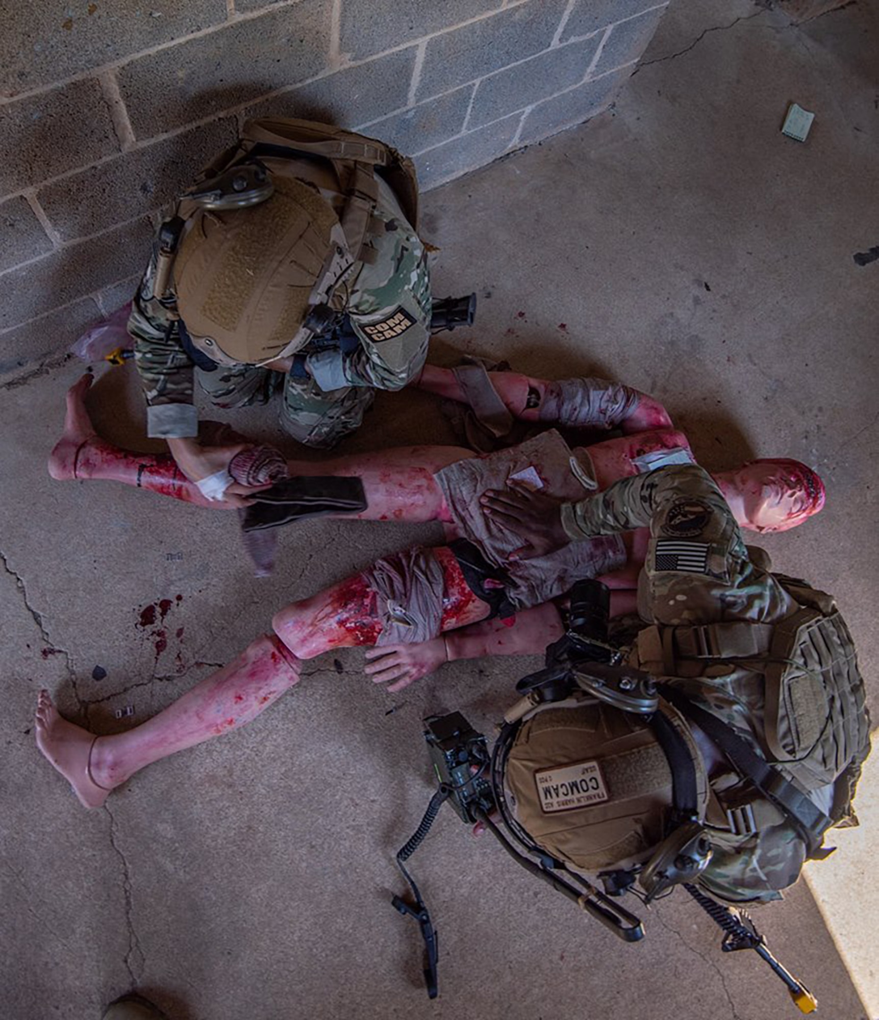 Senior Airman Maygan Straight (top), and Airman 1st Class Franklin Harris, both assigned to 1st Combat Camera Squadron, treat a simulated casualty during the Urban Warfare Simulation lane of the 2018 Hilda I. Clayton Best Combat Camera Competition at Marine Corps Base Quantico, Va., May 2, 2018. The competition is an annual event open to all branches of the military, it's hosted by the 55th Signal Company (Combat Camera) in order to test the technical and tactical proficiencies of Defense Department combat photographers. (U.S. Army photo by Staff Sgt. Pablo N. Piedra)