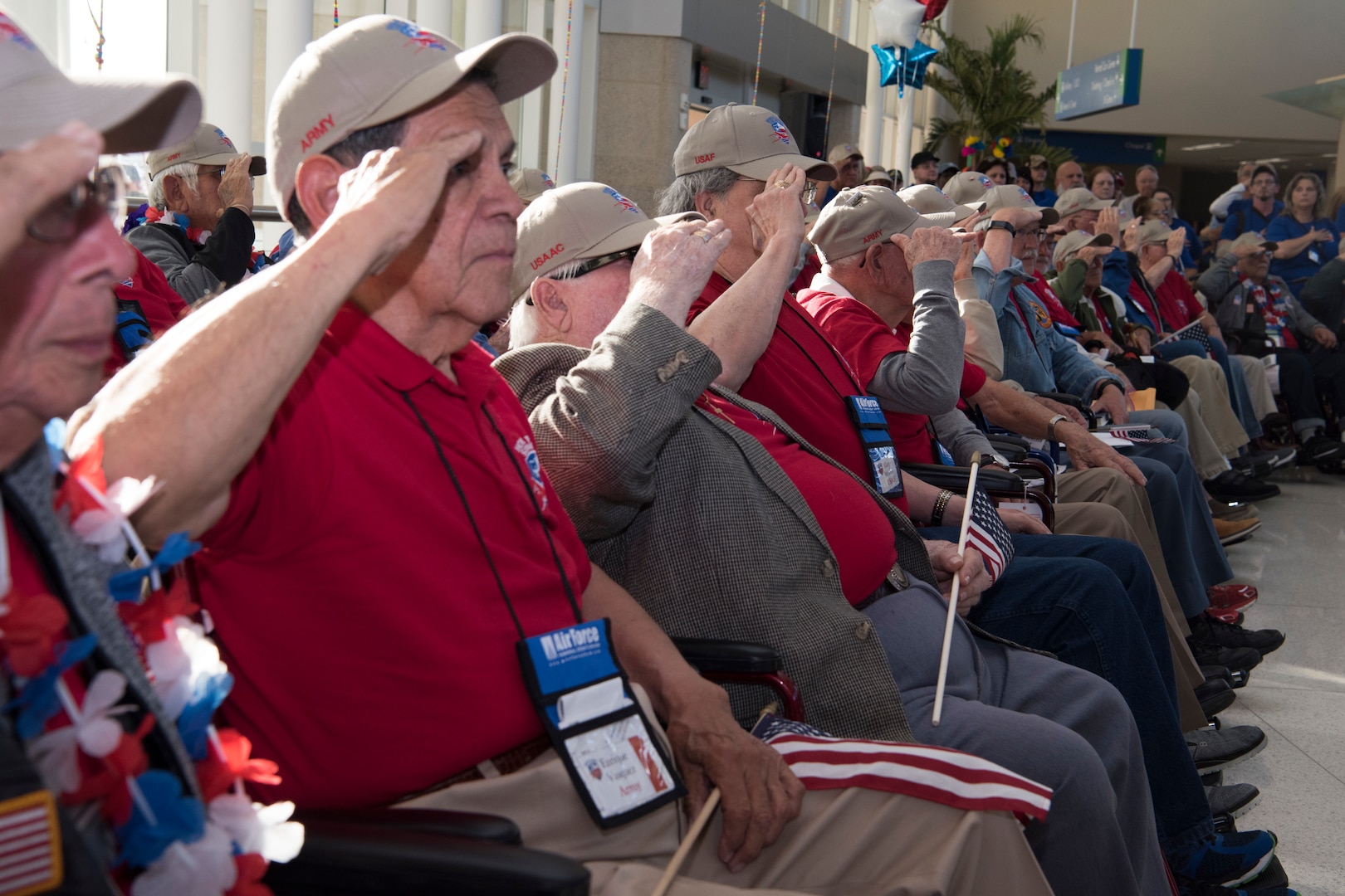 Veterans in the Honor Flight San Antonio salute while the United States National Anthem plays at the Honor Flight San Antonio's welcome home celebration and ceremony. The flight provides final closure and honor for the veterans and a sense of pride for the San Antonio community.