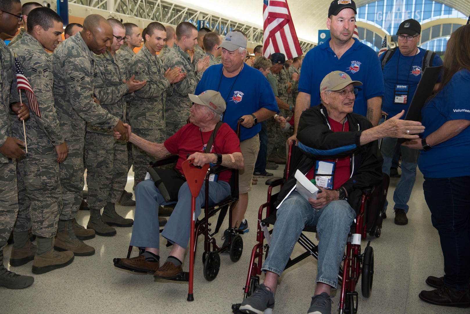 Veterans shake the hands of Airmen and supporters while being pushed by Honor Flight San Antonio volunteer "Guardians" May 5, 2018 .