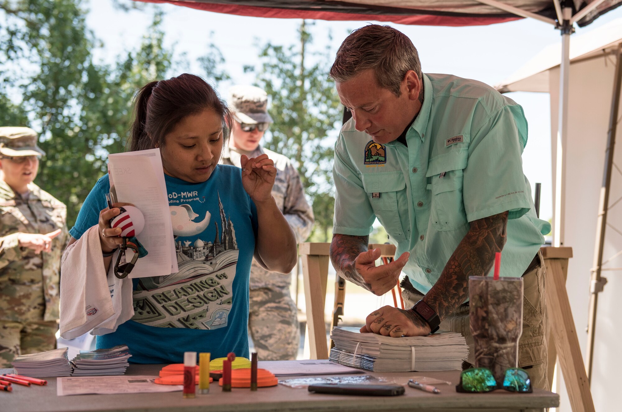 Evelyn Walters, Team Shaw spouse, left, speaks with Marty Long, 20th Force Support Squadron Skeet and Trap Range manager, during the Outdoor Recreation open house at Shaw Air Force Base, S.C., May 9, 2018.