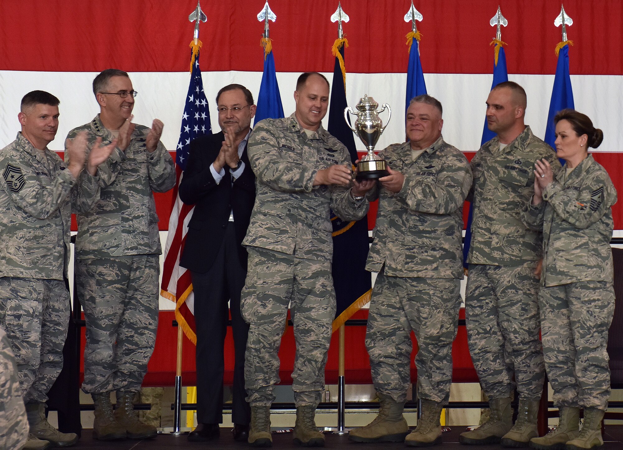U.S. Air Force Brig. Gen. John Nichols, the 509th Bomb Wing commander, center left, and Col. Ken Eaves, the 131st Bomb Wing commander, display the Omaha Trophy at Whiteman Air Force Base, Mo., May 8, 2018. The award was awarded to Team Whiteman by U.S. Strategic Command and the Strategic Command Council for executing the best Strategic Bomber Operations of 2017. (U.S. Air Force photos by Senior Airman Jovan Banks)