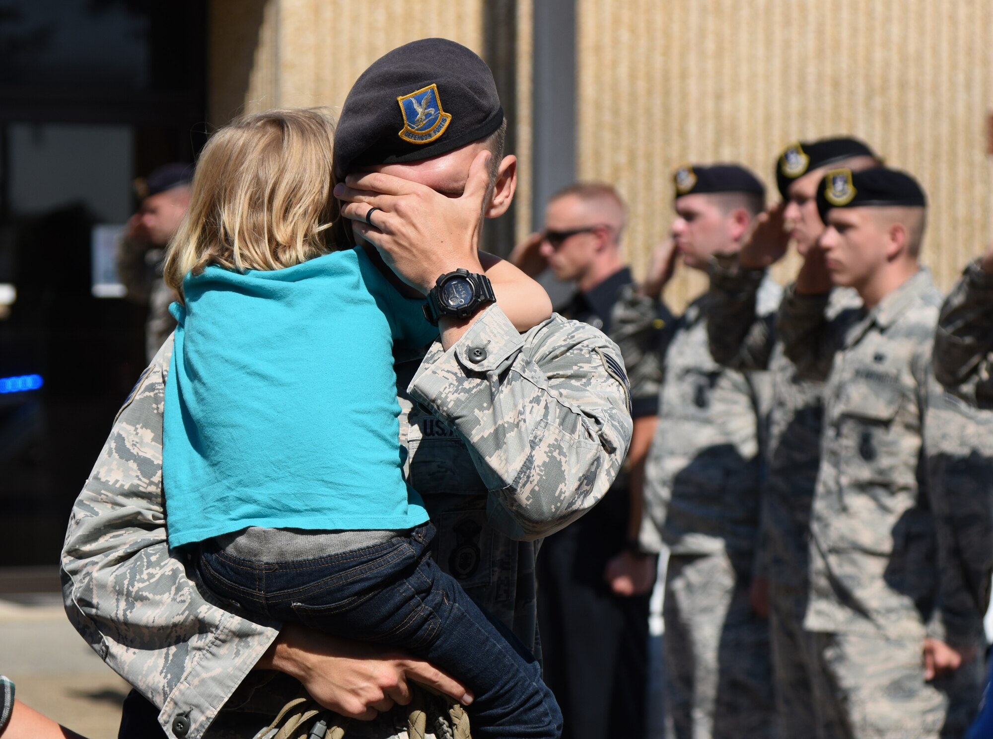 U.S. Air Force Staff Sgt. Jordan Leiter, 81st Security Forces Squadron military working dog trainer, and his son hang on to each other as they mourn their dog, Ares, 81st SFS retired MWD, during a final salute memorial service outside the vet clinic at Keesler Air Force Base, Mississippi, May 9, 2018. Leiter adopted Ares over a year ago and they served together for four years, which included a combat operation deployment to Kuwait. (U.S. Air Force photo by Kemberly Groue)